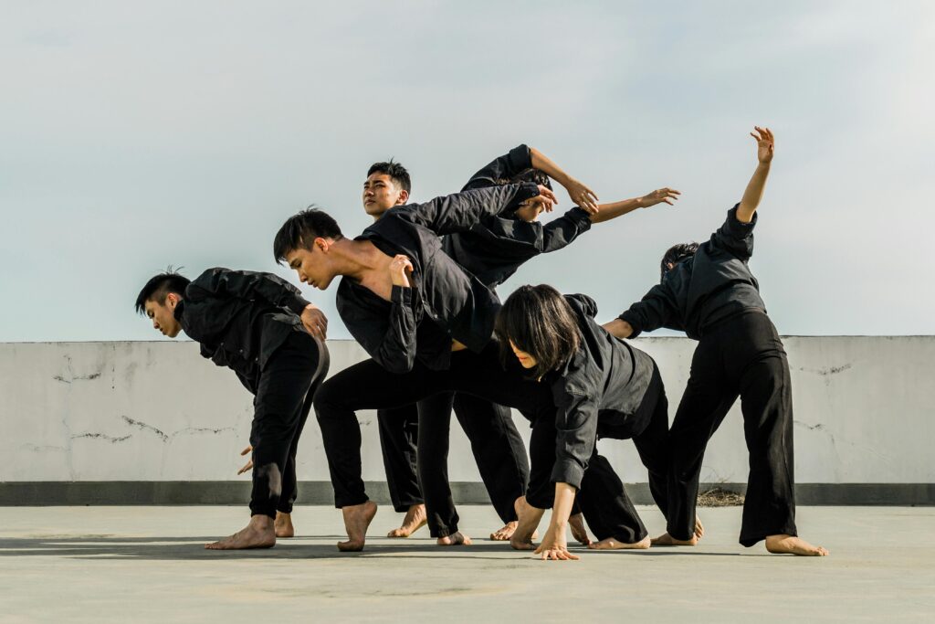 Un groupe d'adultes exécute une danse contemporaine dynamique sur un toit.